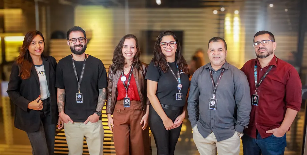 Seis integrantes do time da Just Travel lado a lado no escritório